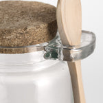 glass storage jar with cork lid and wooden spoon.