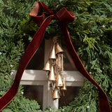 Decorative wreath with gold bells and red ribbon against a green background