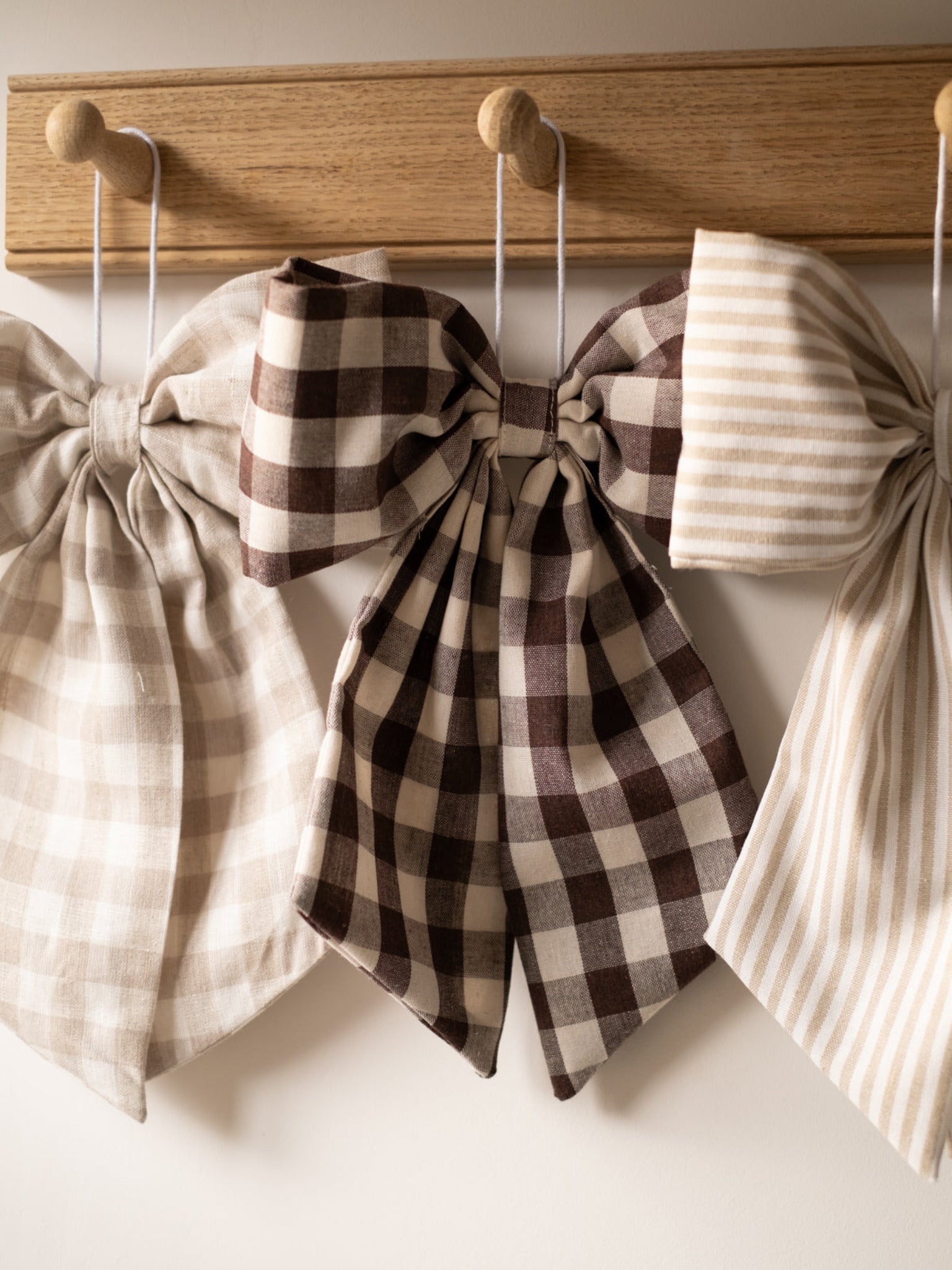 Cream and Beige Gingham Hanging Bow with a red and white bow sitting in the middle