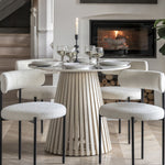 Dining chair upholstered in cream fabric with black metal legs