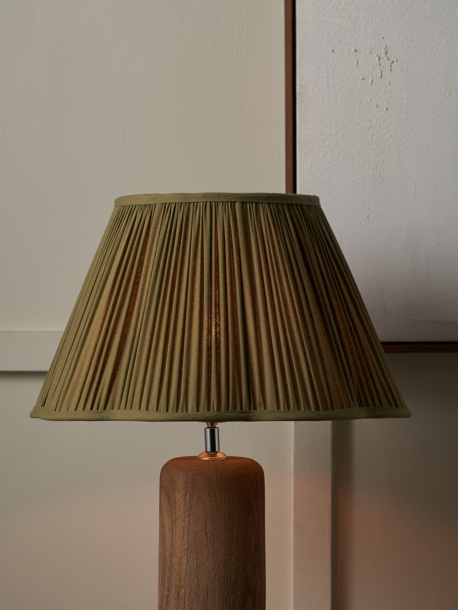 a green shade with a wooden bace and on a grey background. 