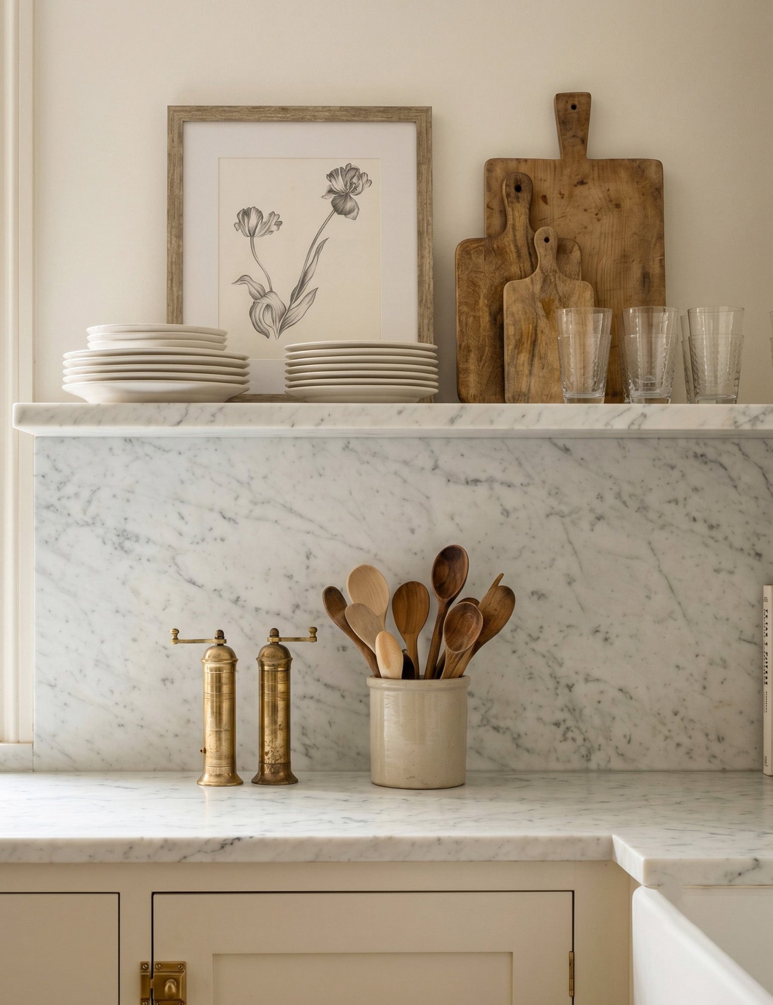 Kitchen counter with marble backsplash, wooden cutting boards, and kitchen utensils.