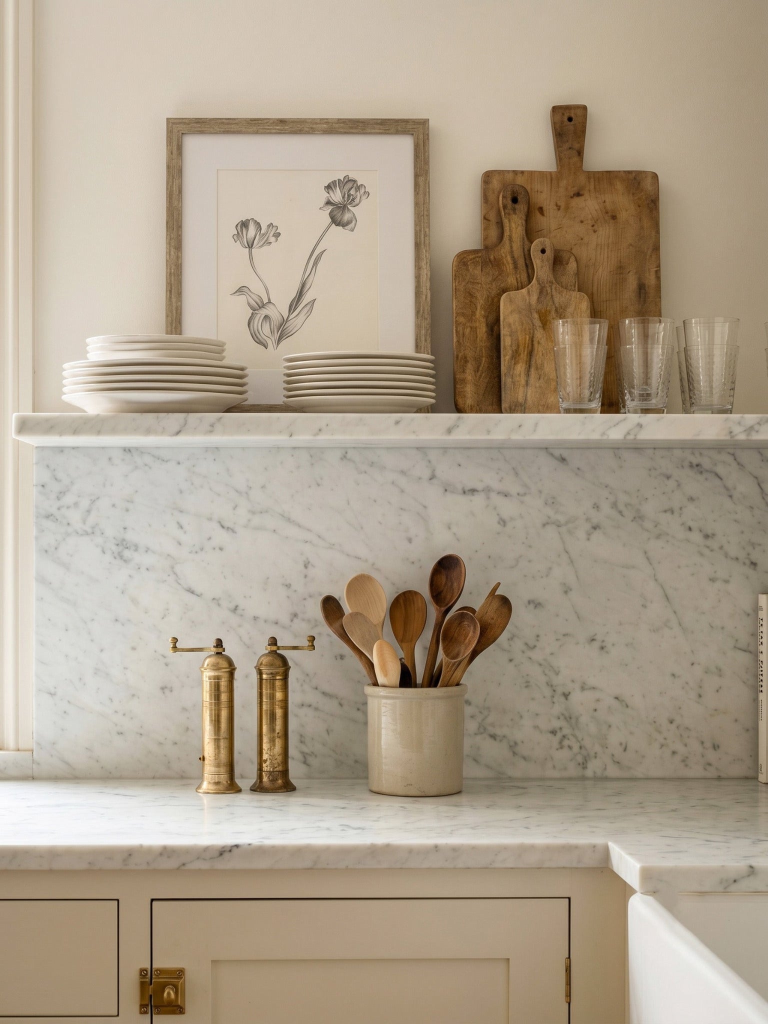 Kitchen counter with marble backsplash, wooden cutting boards, and kitchen utensils.