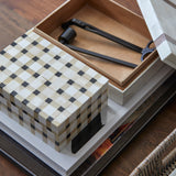 Checkered box with tools inside on a wooden surface