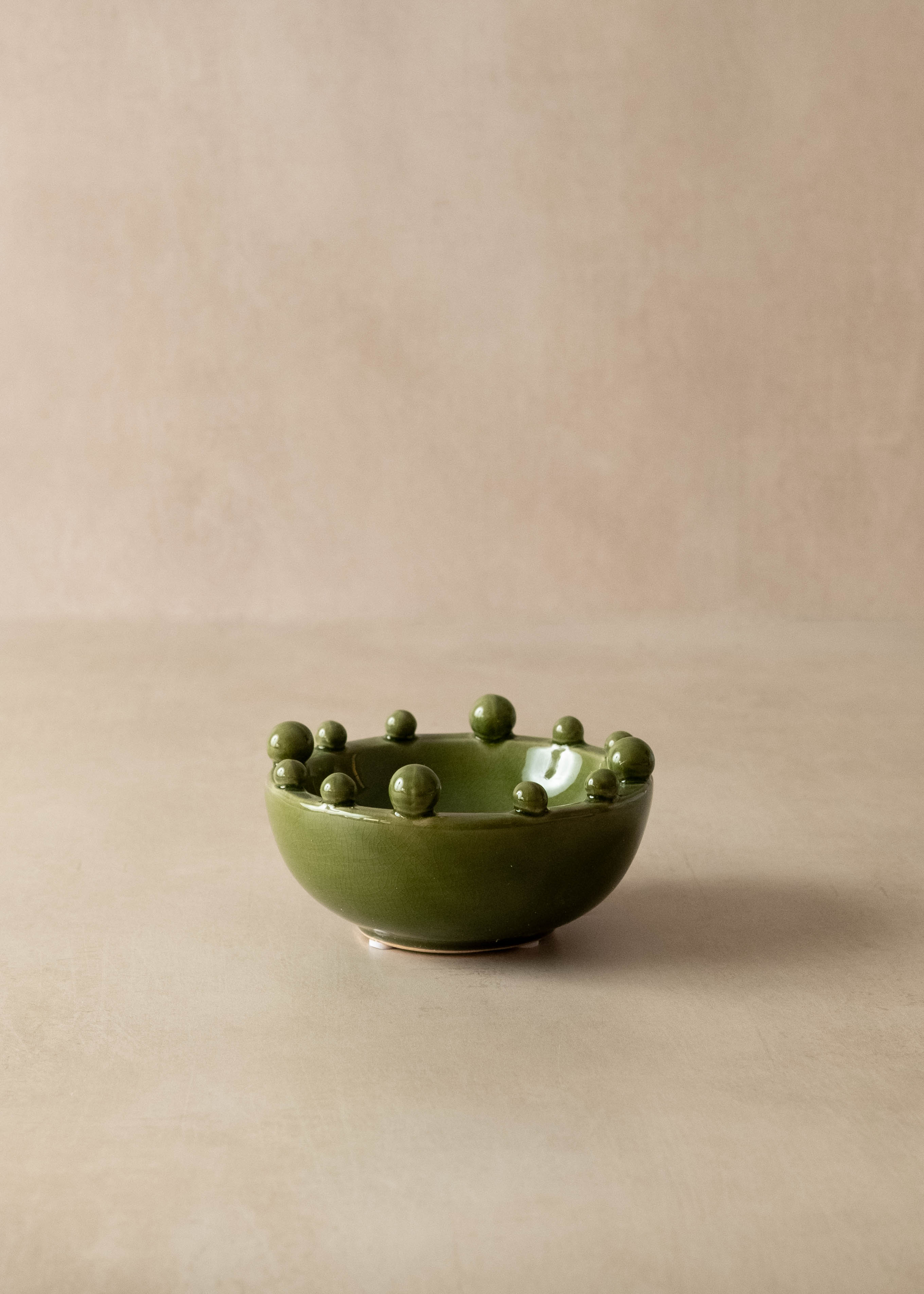 Green ceramic bowl with small green balls