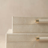 Beige jewelry box with gold accents on a beige background