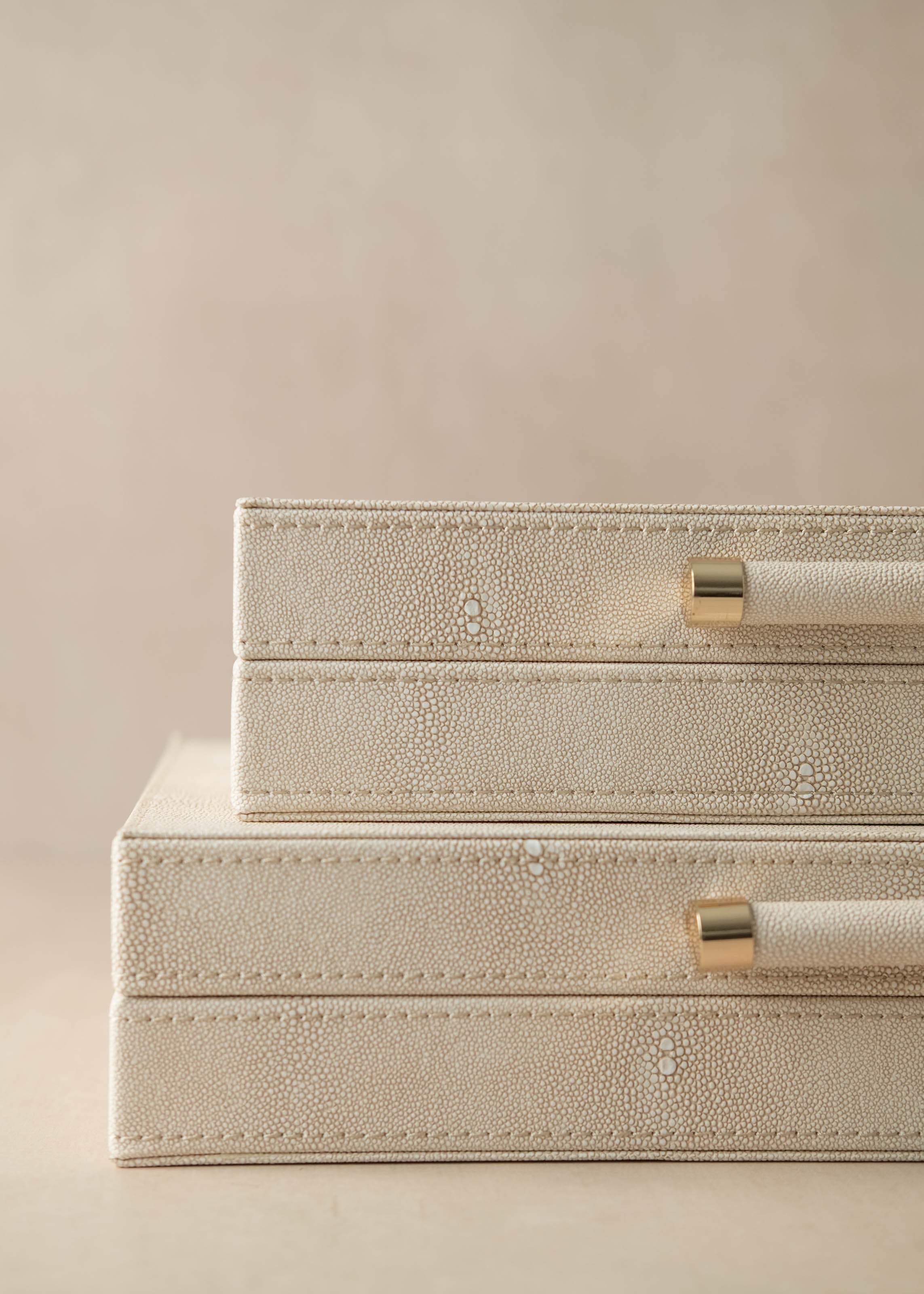 Beige jewelry box with gold accents on a beige background