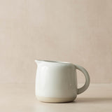 White ceramic pitcher on a beige background