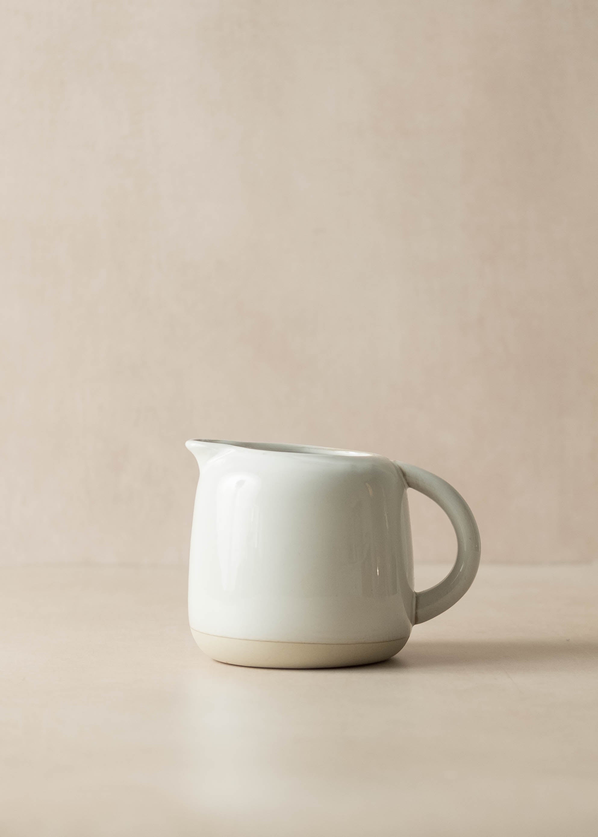 White ceramic pitcher on a beige background