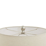 Close-up of a beige lampshade with a metallic finial on a white background