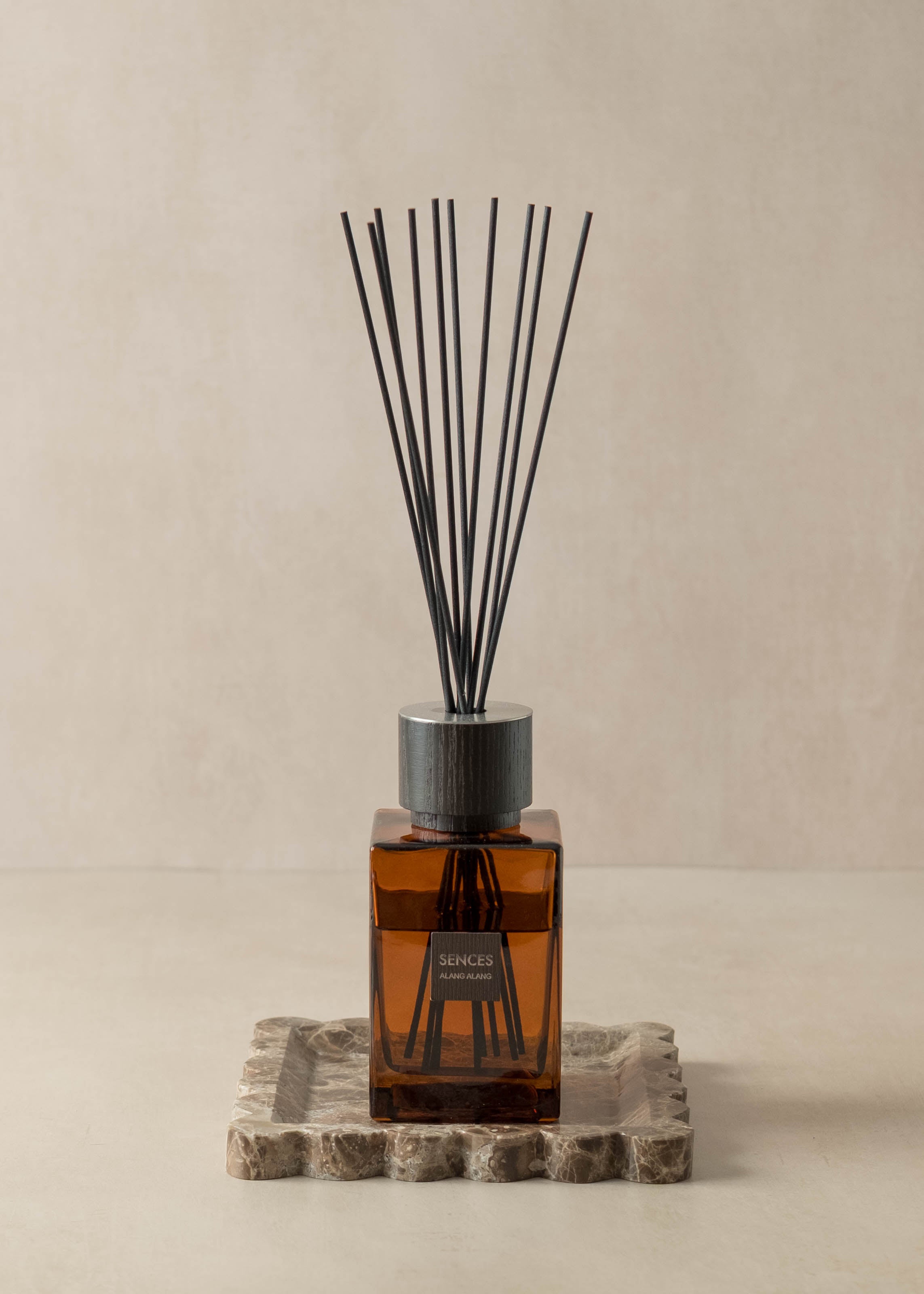 Reed diffuser with black reeds on a beige background