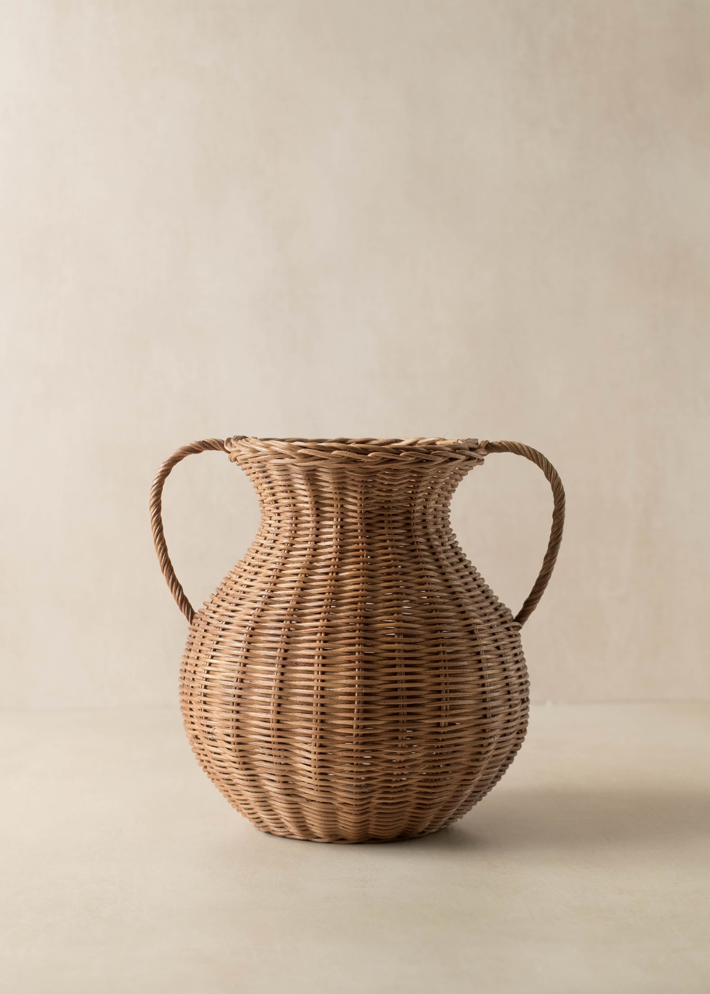 Woven rattan vase with handles on a beige background - McGee and Co style